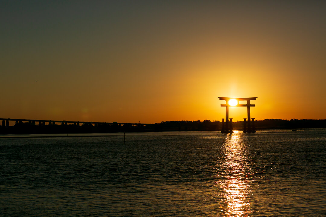 弁天島海浜公園から撮影した鳥居と夕日の写真