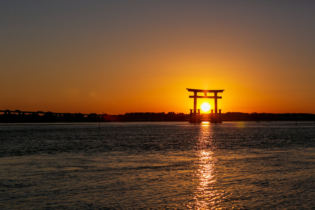 弁天島海浜公園から撮影した鳥居と夕日の写真